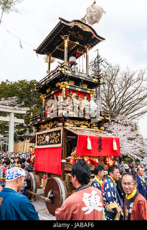 Inuyama festival in Japan, massive 3 storey wooden Dashi float, also called yatai or yama, in city square with spectators and Dashi team members. Stock Photo