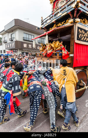 Inuyama festival in Japan, massive 3 storey wooden Dashi float, also called yatai or yama, being pushed through spectator crowded street Stock Photo