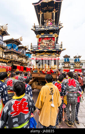 Inuyama festival in Japan, massive 3 storey wooden Dashi float, also called yatai or yama, being pushed through spectator crowded street Stock Photo