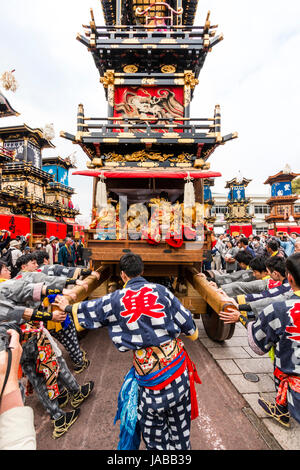 Inuyama festival in Japan, massive 3 storey wooden Dashi float, also called yatai or yama, being pushed through spectator crowded street Stock Photo