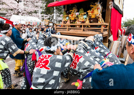 Inuyama festival in Japan, massive 3 storey wooden Dashi float, also called yatai or yama, being pushed through spectator crowded street Stock Photo