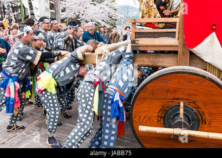 Inuyama festival in Japan, massive 3 storey wooden Dashi float, also called yatai or yama, being pushed through spectator crowded street Stock Photo