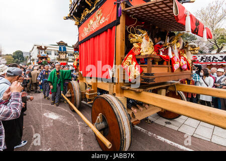 Inuyama festival in Japan, massive 3 storey wooden Dashi float, also called yatai or yama, in city square with spectators and Dashi team members. Stock Photo