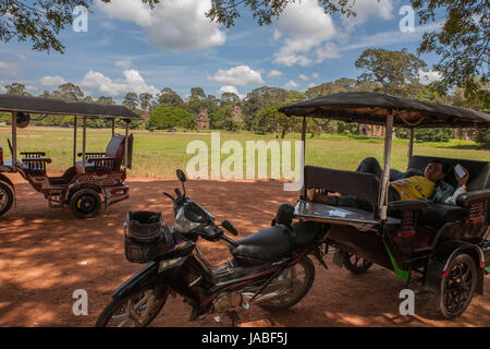 Tuk-tuks await passengers, Prasat Suor Prat beyond: Angkor Thom, Siem Reap, Cambodia Stock Photo