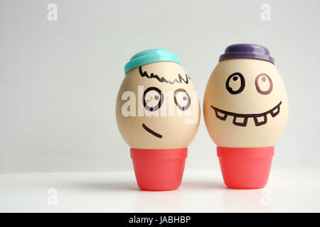 Egg with painted face. Two eggs in caps. Photo for your design Stock Photo
