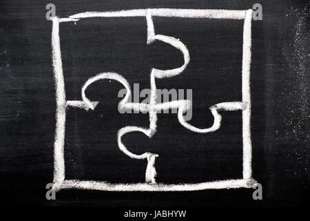 Chalk hand drawing as puzzle shape on black board background Stock Photo