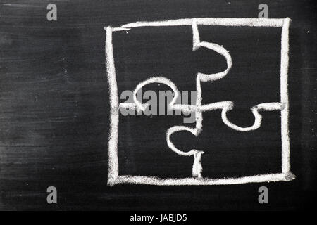Chalk hand drawing as puzzle shape on black board background Stock Photo
