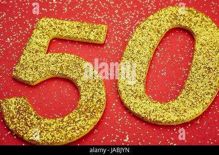 Number fifty golden color over a red background. Anniversary. Horizontal Stock Photo