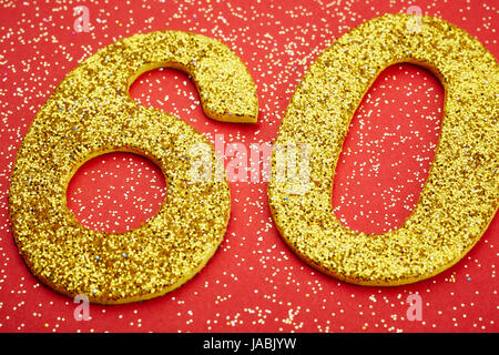 Number sixty golden color over a red background. Anniversary. Horizontal Stock Photo