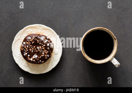 Cup of coffee black espresso and chocolate donut glazed confetti on stone background. Top view. Food design mockup Stock Photo