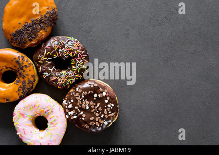 Glazed donuts on dark background. Table top view and copy space Stock Photo