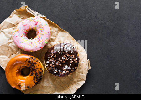 Glazed donuts on dark background. Table top view and copy space Stock Photo