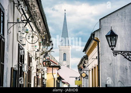 Hrnciarska street with Calvinist church in Kosice, Slovak republic. Folk art theme. Beauty photo filter. Religious architecture. Stock Photo