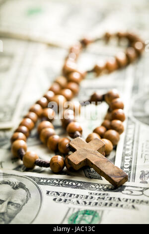 rosary beads lying on us dollars backround Stock Photo
