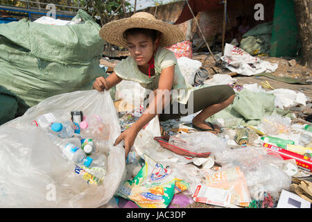 A teenager sorts recyclable materials at her home in Mandalay, Myanmar (Burma) Stock Photo