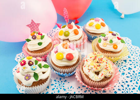 Birthday Cupcakes with Balloons on a Blue Background. Stock Photo