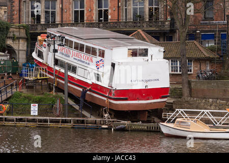 Pleasure cruise boat, Captain James Cook out of the water on a slipway, being repaired & refurbished, 1 man working - River Ouse, York, England, UK. Stock Photo