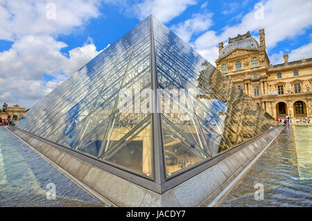 PARIS - JUNE 06: Glass Pyramid of Louvre and Royal Palace on background. Pyramid is one of the main touristic sites ans serves also as entrance to Louvre museum on June 06, 2012 in Paris, France. Stock Photo