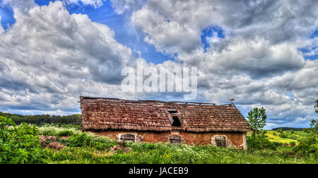 Blue cloudy sky over stork sitting on the edge of barn, HDR image, Poland, Europe Stock Photo
