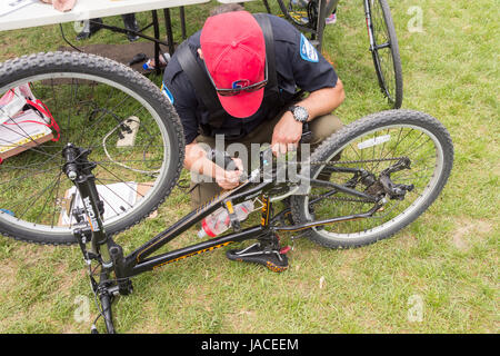 Montreal, Canada - 4 June 2017: A police officer is engraving a bike with an ID number at Park Jeanne to reduce bicycle thefts Stock Photo
