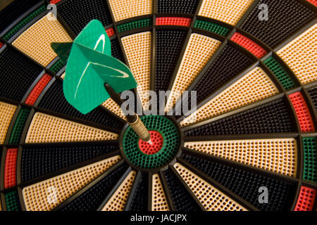 Dart hits dead center of dart board. Stock Photo