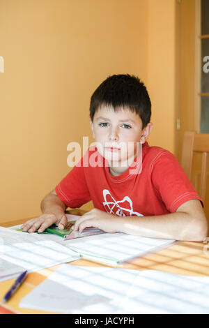 boy doing school homework from geometry mathematics in workbook Stock Photo