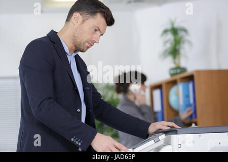 businessman hand pressing printers button in office Stock Photo