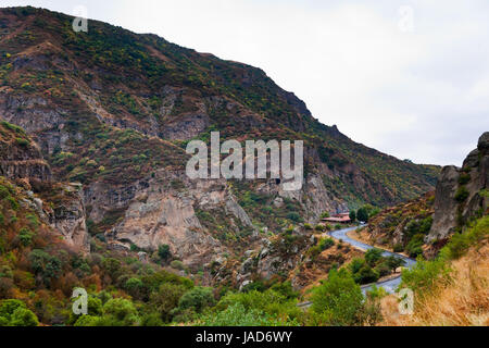 Cliffs and the road in gorge of Azat river in Armenia. Cliffs surrounding Geghard monastery and Azat river gorge are included together with the monastery in the World Heritage Site listing. Stock Photo
