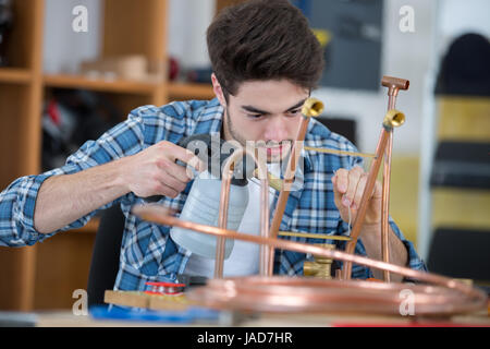 young plumber using welding gas torch to solder copper pipes Stock Photo
