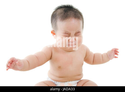 Upset Asian baby boy crying, sitting isolated on white background Stock Photo