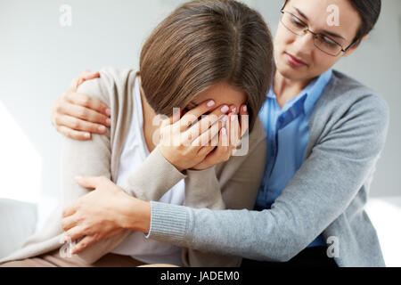 Image of compassionate psychiatrist comforting her crying patient Stock Photo