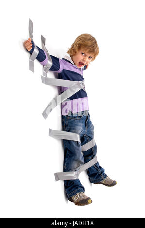 Young angry boy glued to the wall with duct tape Stock Photo