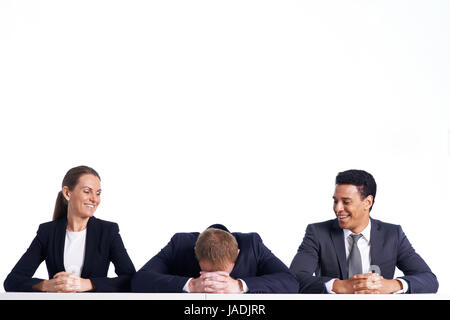 Portrait of smiling business partners looking at their colleague keeping his head on crossed hands Stock Photo