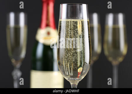 Sekt im Sektglas mit einer Sektflasche und weiteren Sektgläsern im Hintergrund Stock Photo