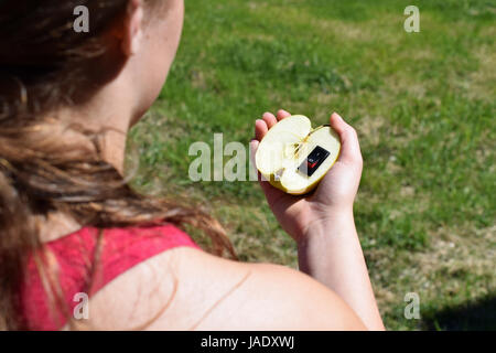 Unique healthy food concept. Hand holding apple with inserted power switch as meaning a change to healthier life. Stock Photo
