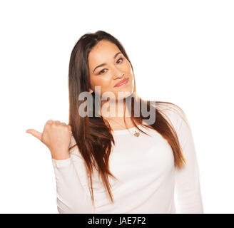 Smiling beautiful young woman gesturing with her thumb either giving a thumbs up gesture of approval and success or thumbing a lift isolated on white Stock Photo