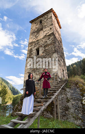Georgian man and woman in national costumes in the village Ushguli, Georgia. Stock Photo