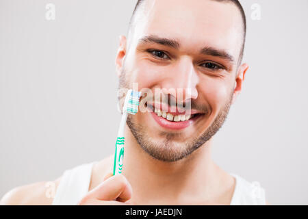Young man holding toothbrush. Dental hygiene concept. Stock Photo