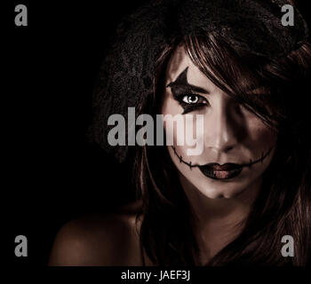 Terrifying witch portrait isolated on black background, attractive woman with scary makeup, Halloween party, horror concept Stock Photo
