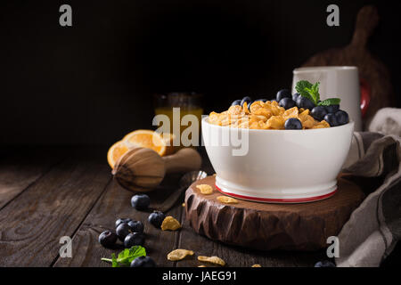 Healthy breakfast with corn flakes, berries and milk on old dark wooden background. Copy space. Stock Photo