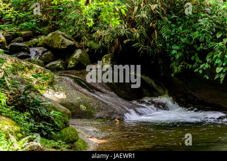 Small river and waterfall between the Itatiaia National Park rocks in Penedo, Rio de Janeiro Stock Photo