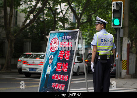 Shanghai, China. 7th June, 2017. A traffic police is on duty outside the exam venue of the national college entrance examination at No. 54 Middle School in Shanghai, east China, June 7, 2017. A total of 9.4 million Chinese students sit the annual national college entrance examination from Wednesday. Credit: Du Xiaoyi/Xinhua/Alamy Live News Stock Photo