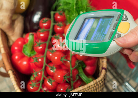 Woman customer using scanner device in supermarket. Automatic object recognition. Stock Photo