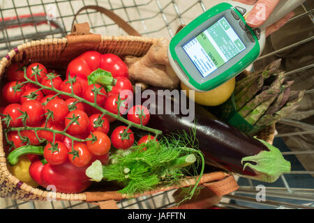 Woman customer using scanner device in supermarket. Automatic object recognition. Stock Photo