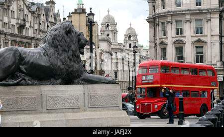 June 5, 2017 - A London Red Bus near one of Sir Edwin Lutyens famous bronze lions in Trafalgar Square in the City of Westminster, Central London Stock Photo
