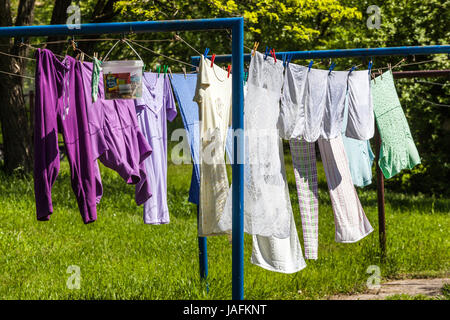 Drying Laundry Hanging on Clothesline Garden Outside Clothing Laundry hanging Clothes Laundry on clothesline Freshly Sunny day Clothesline garden Stock Photo