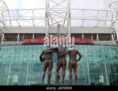 A statue of Manchester United's 'Holy Trinity' of Sir Bobby Charlton, George Best and Denis Law outside the stadium before the game Stock Photo