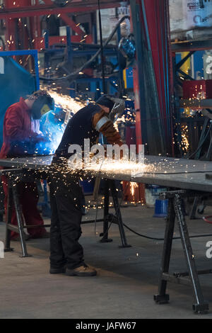 Workers in a factory working with metal on the shop floor. Stock Photo