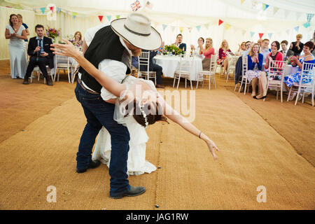 Bride and groom dancing together inside a marquee. Stock Photo
