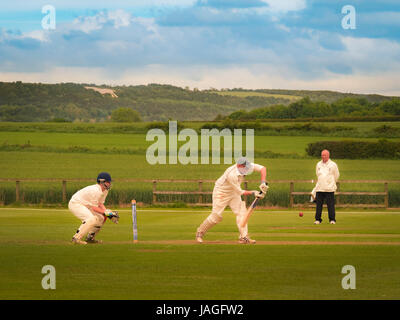 Game of Cricket being played in typical British village of Sessay with the White Horse in the background. Stock Photo